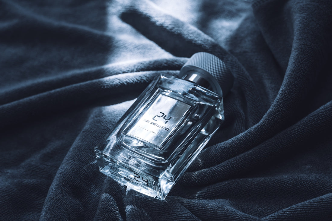 A clear glass perfume bottle on a dark cloth